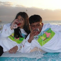 two people laying on a blanket at the beach